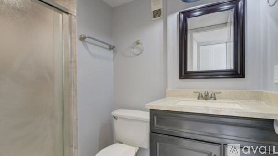 A bathroom with a toilet, sink, and mirror.