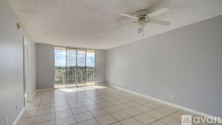A spacious room with a ceiling fan and tiled floor.