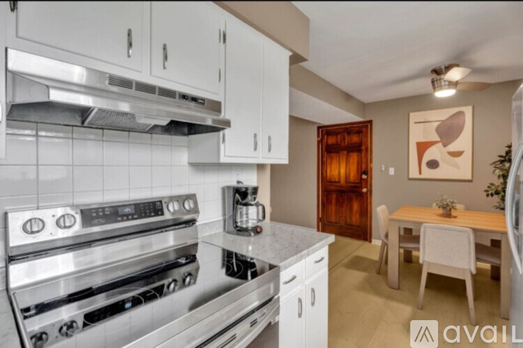 A modern kitchen with white cabinets and a stainless steel oven.