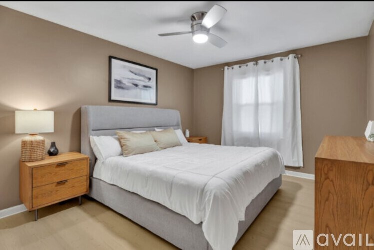 A bedroom with a bed, nightstand, and a ceiling fan.