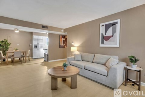A living room with a couch, coffee table, and a painting on the wall.