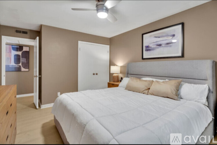 A bedroom with a large bed and a ceiling fan.
