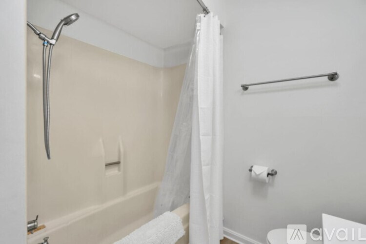 A white shower curtain hangs in a bathroom.