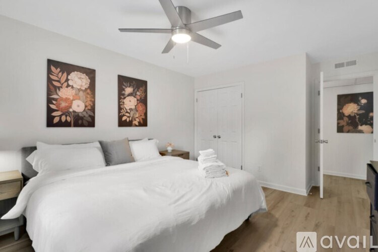 A bedroom with a large bed and a ceiling fan.