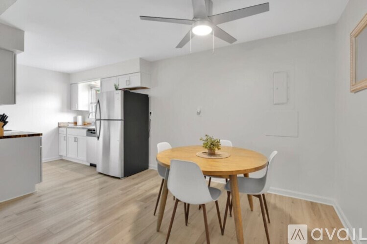 A kitchen with a dining table and chairs.