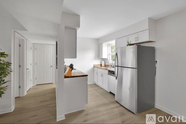 A kitchen with white cabinets and a wooden island.