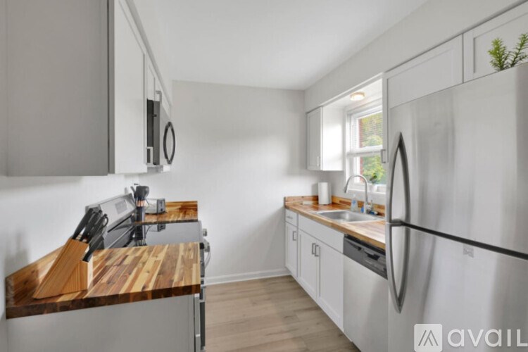 A modern kitchen with a wooden countertop and stainless steel appliances.