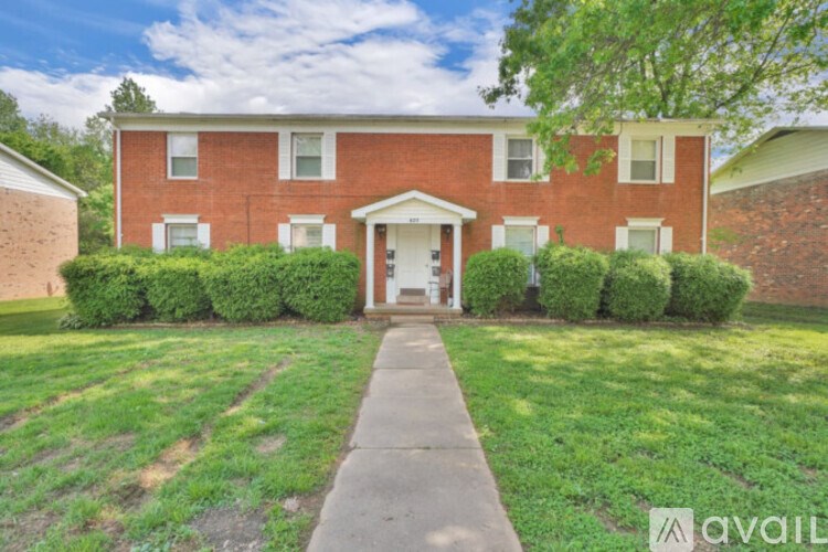 A red brick house with a white door and windows.