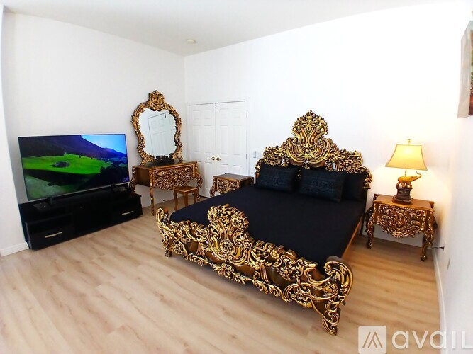 A living room with a black couch and a television.