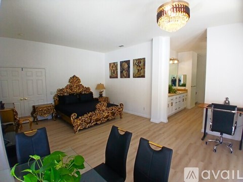 A living room with a black couch and a television.
