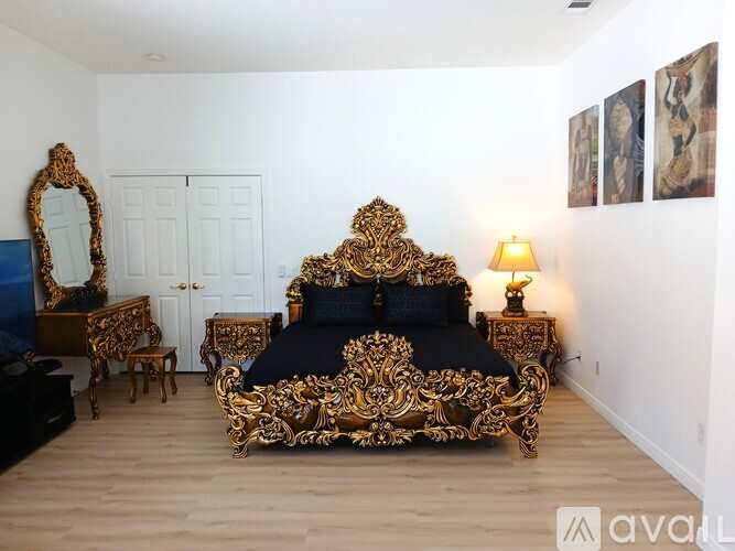 A bedroom with a large ornate bed and matching furniture.