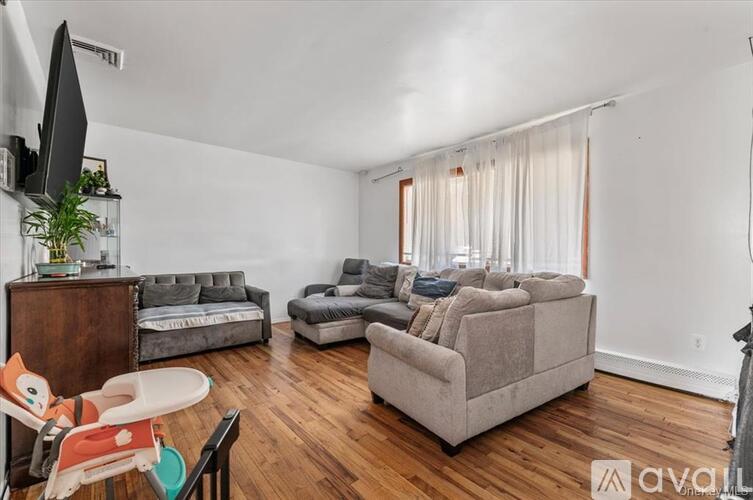 A room with wooden flooring and a balcony with a railing.