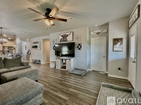 A living room with a grey sofa and a wooden floor.