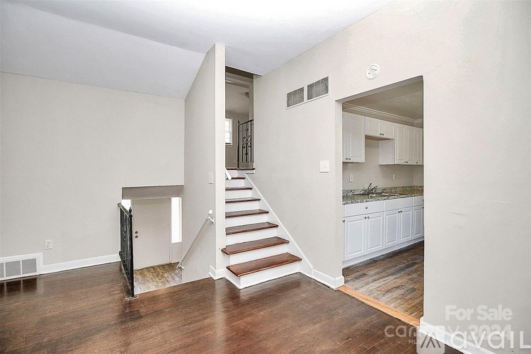 A spacious living room with a staircase leading to the upper floor.