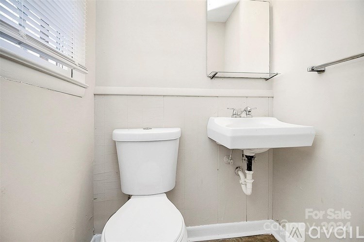 A white toilet and sink in a small bathroom.