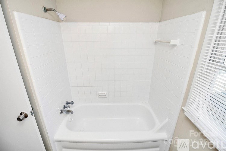 A white bathroom with a tub and a shower.