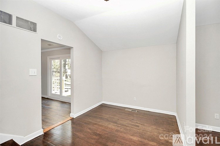 A room with a white wall and a window.