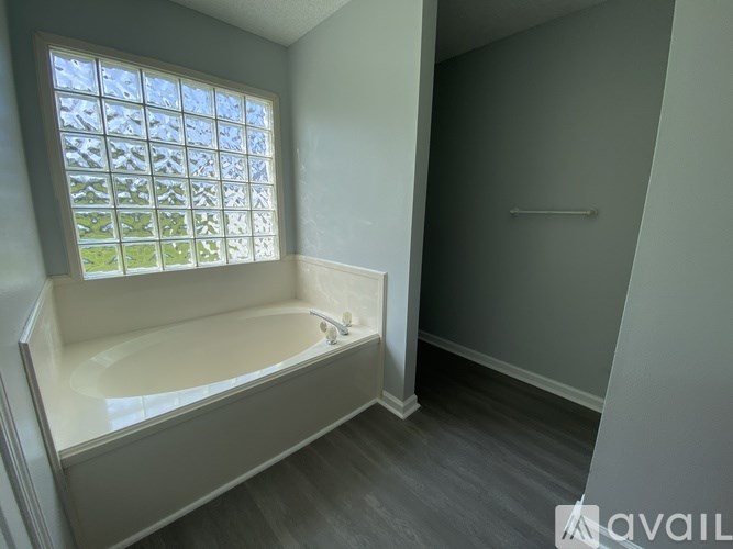 A bathroom with a tub and a window.