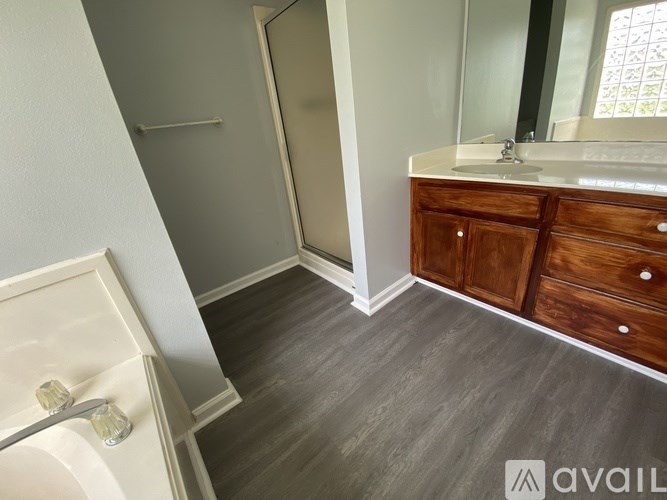 A bathroom with a white sink and a wooden cabinet.