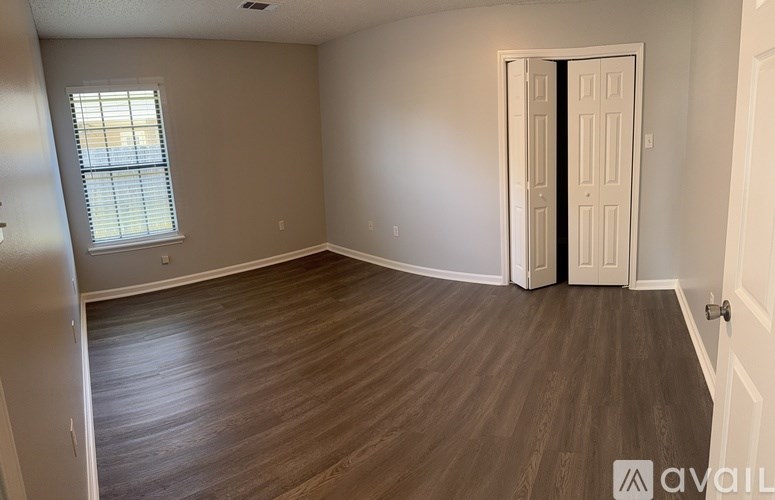 A room with wooden flooring and a white door.