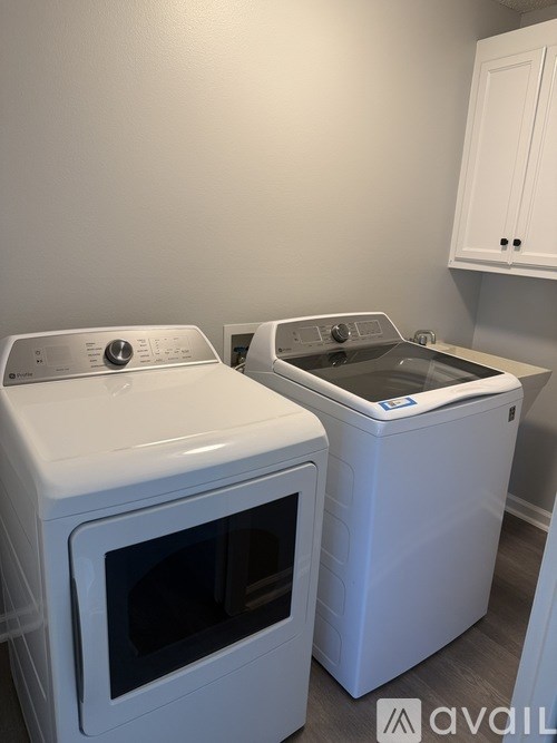 Two white front loading washing machines in a laundry room.