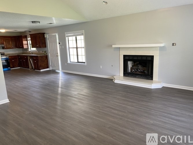 A living room with a fireplace and wood flooring.