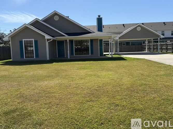 A spacious living room with wood flooring and a kitchen in the background.