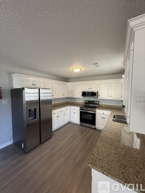 A room with wooden flooring and a window with blinds.