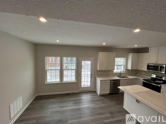 A spacious kitchen with a dining area and a window.