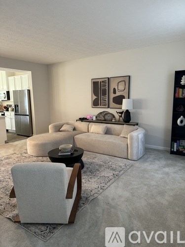 A living room with a white couch, a chair, and a coffee table.