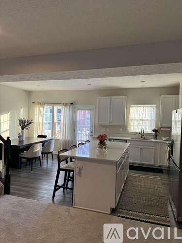 A kitchen with a dining table and chairs.