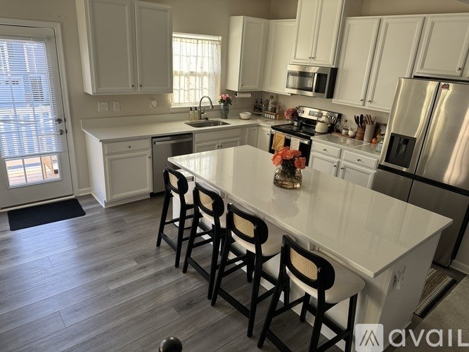 A kitchen with white cabinets and a large island.
