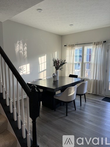 A dining room with a table and chairs.