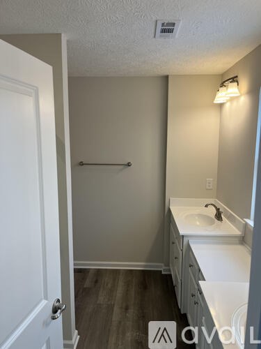 A bathroom with a white sink and a white door.