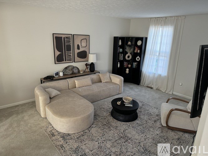 A living room with a large couch, a coffee table, and a television.