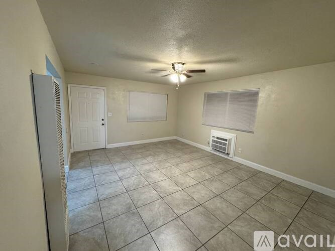 A room with a ceiling fan and tile flooring.