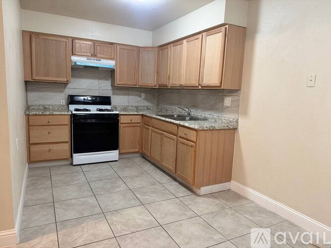 A kitchen with wooden cabinets and a black oven.