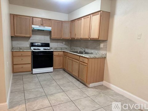 A kitchen with wooden cabinets and a black oven.