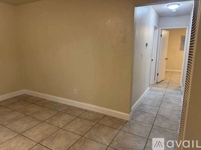 A room with beige walls and tiled flooring.