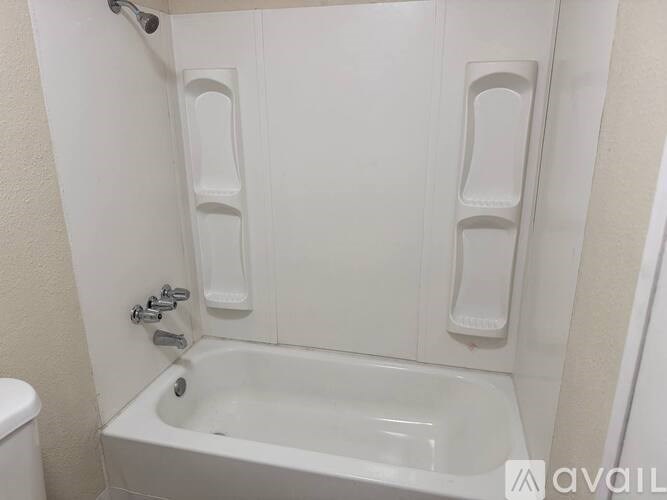 A white bathroom with a tub and toilet.