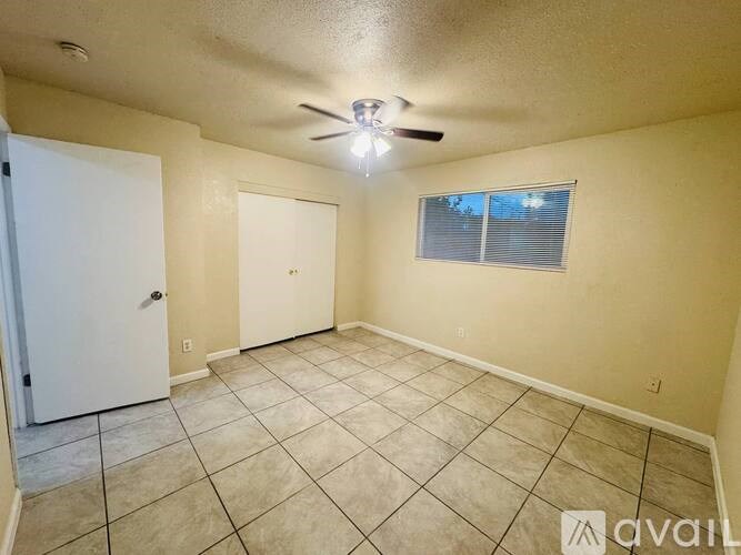 A room with a ceiling fan and tile flooring.