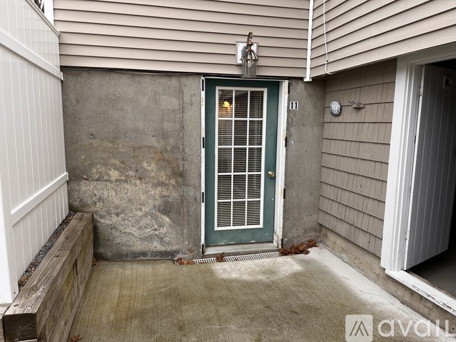 A green door with bars is the only entrance to a house.