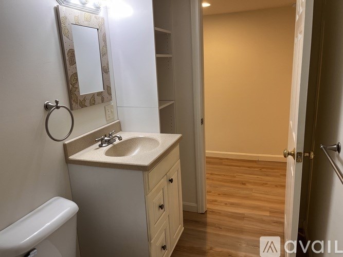 A bathroom with a sink, mirror, and toilet.
