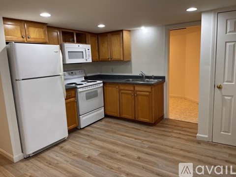 A kitchen with wooden cabinets and a white refrigerator.