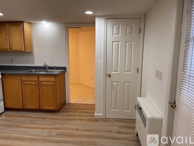 A kitchen with wooden cabinets and a white door.