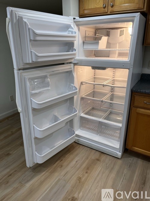 A white refrigerator with its door open and shelves visible.