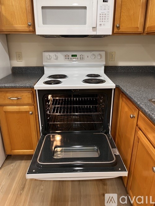 A white oven with the door open is in a kitchen.