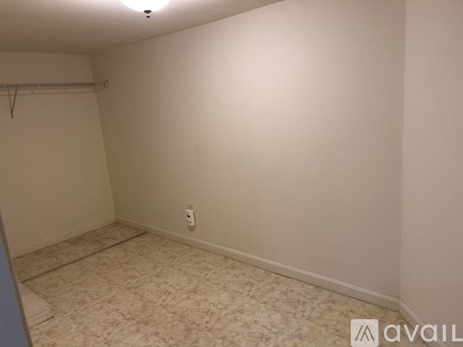 A room with a carpeted floor and a white wall.