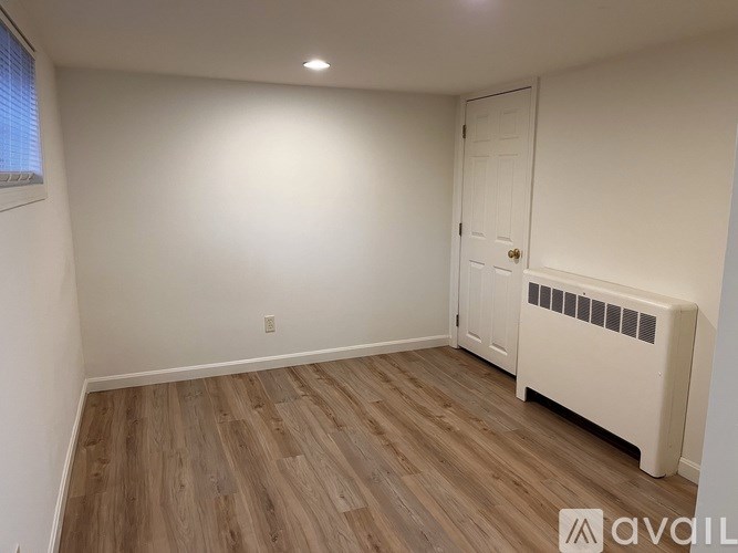 A room with a white door and a radiator on the wall.