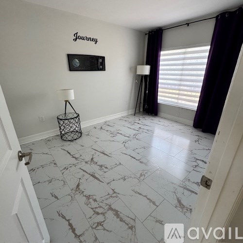 A room with a white marble floor and a purple curtain.